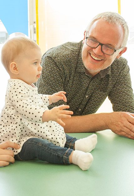 Der Kinderarzt Dr. Elsbroek bei der Untersuchung eines Kleinkindes