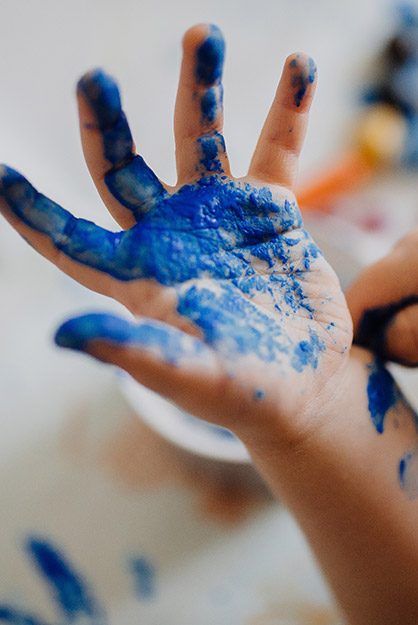Kinderhand mit Fingerfarbe