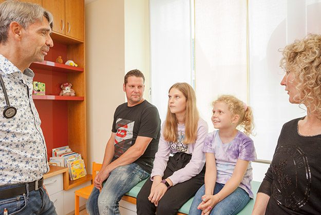 Kinderarzt Dr. Steeg im Gespräch mit einer Familie